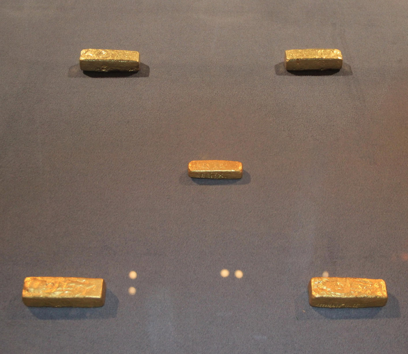Экспозиция золотых брусков с надписью.